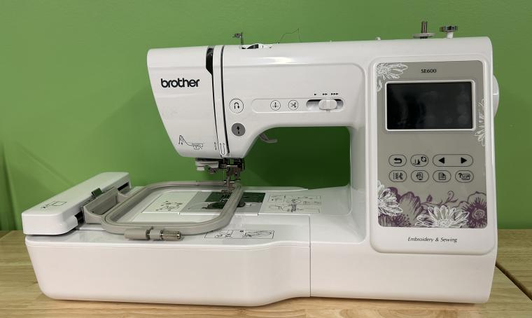 A picture of a Brother SE600 embroidery machine against a green background.