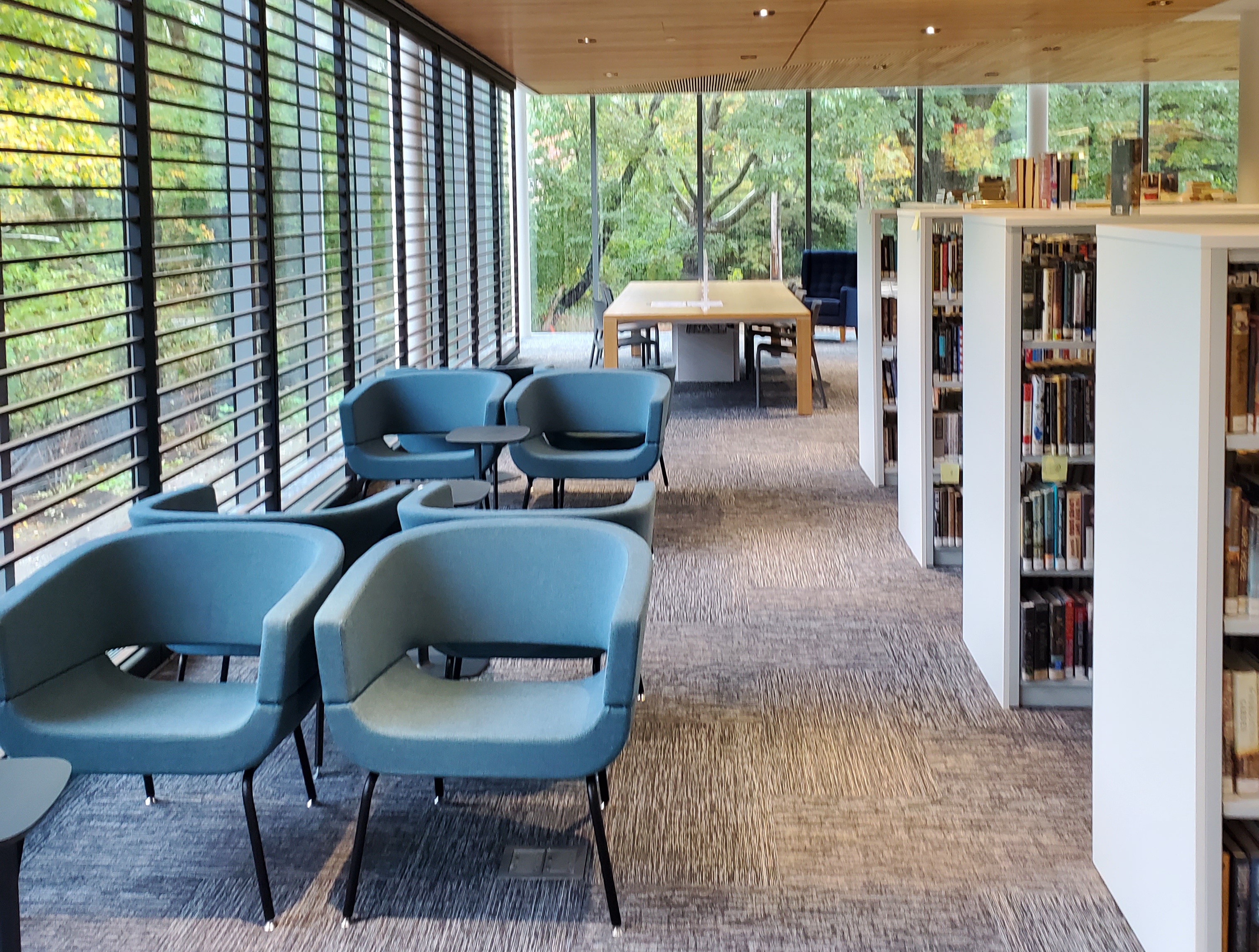 Interior photo showing the Reading Room with lounge chairs and bookstacks