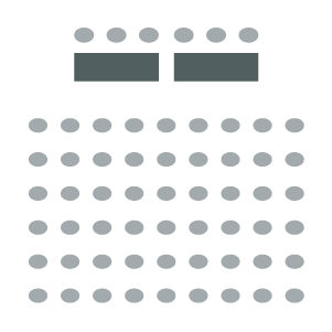 Auditorium Panel showing a seating area and two tables at the front for presenters