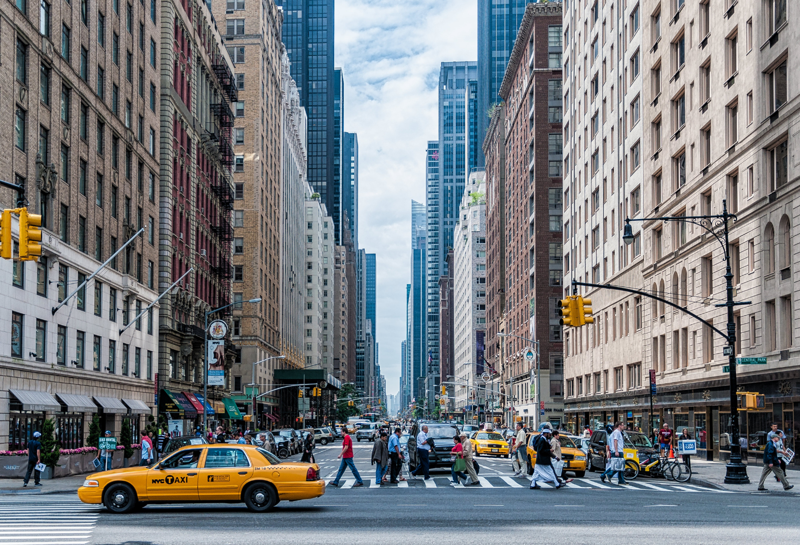 Street view of New York City with yellow cab and people crossing the street