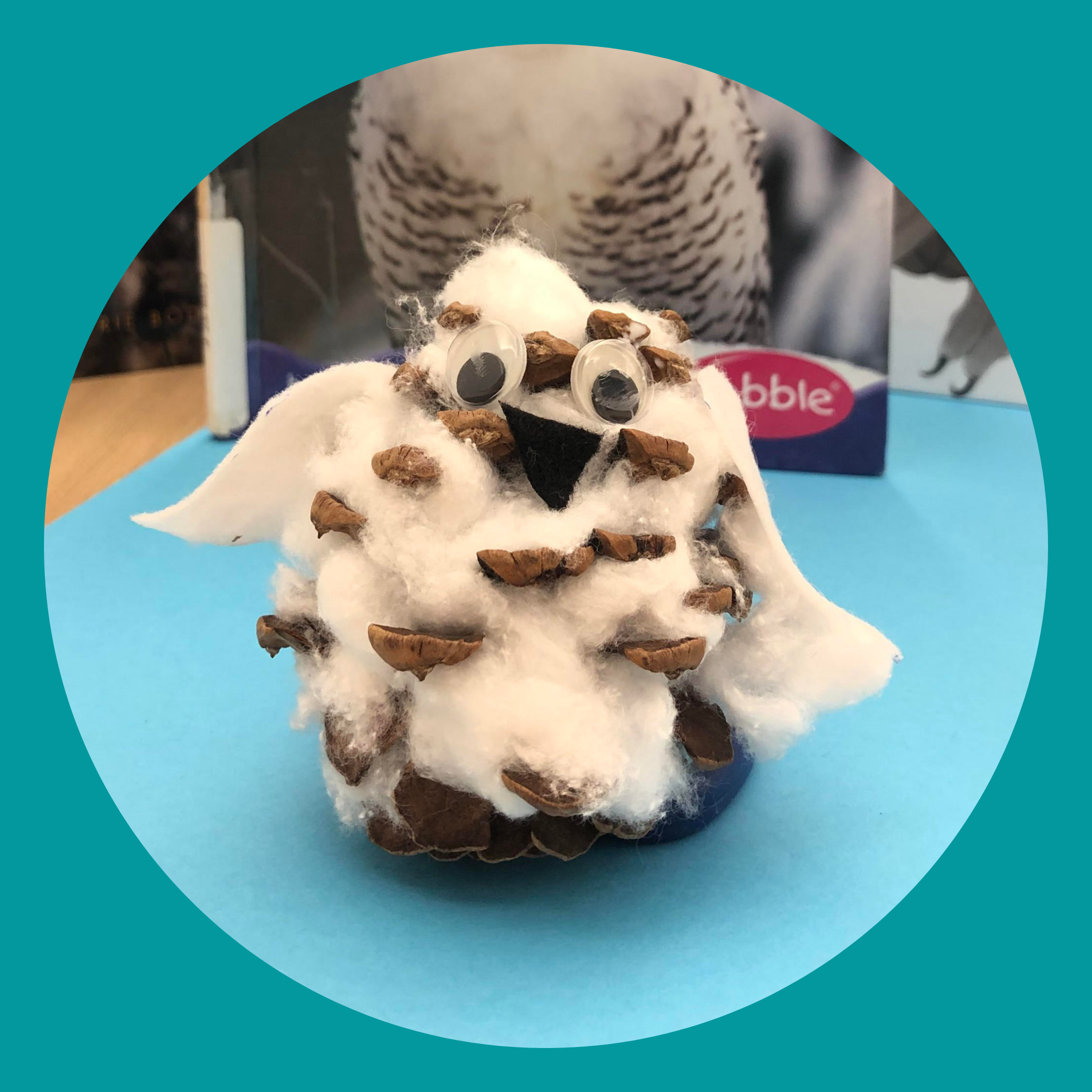 Snowy owl craft made out of a pinecone
