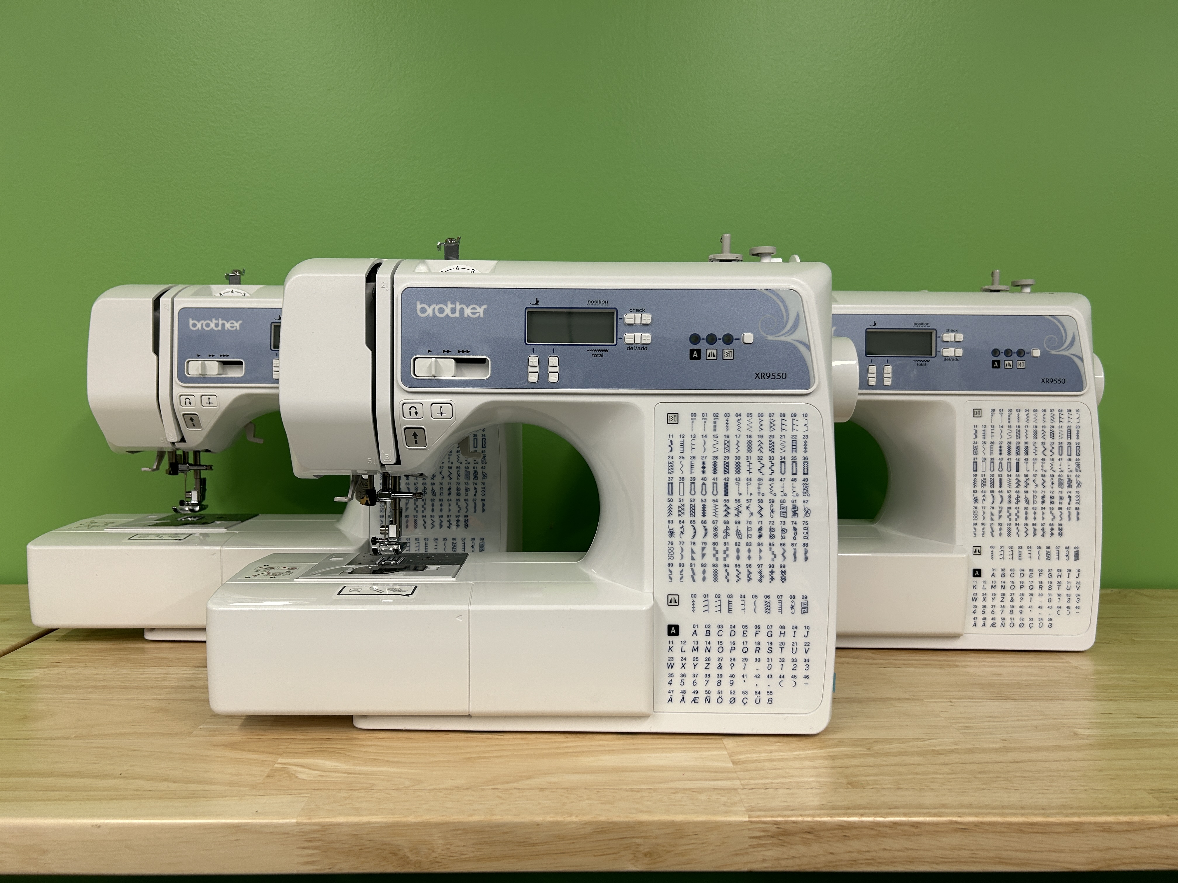 Three Brother XR9550 sewing/quilting machines against a green background