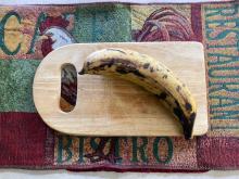 Single banana on cutting board