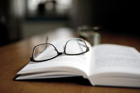 Open book with reading glasses on top of the page